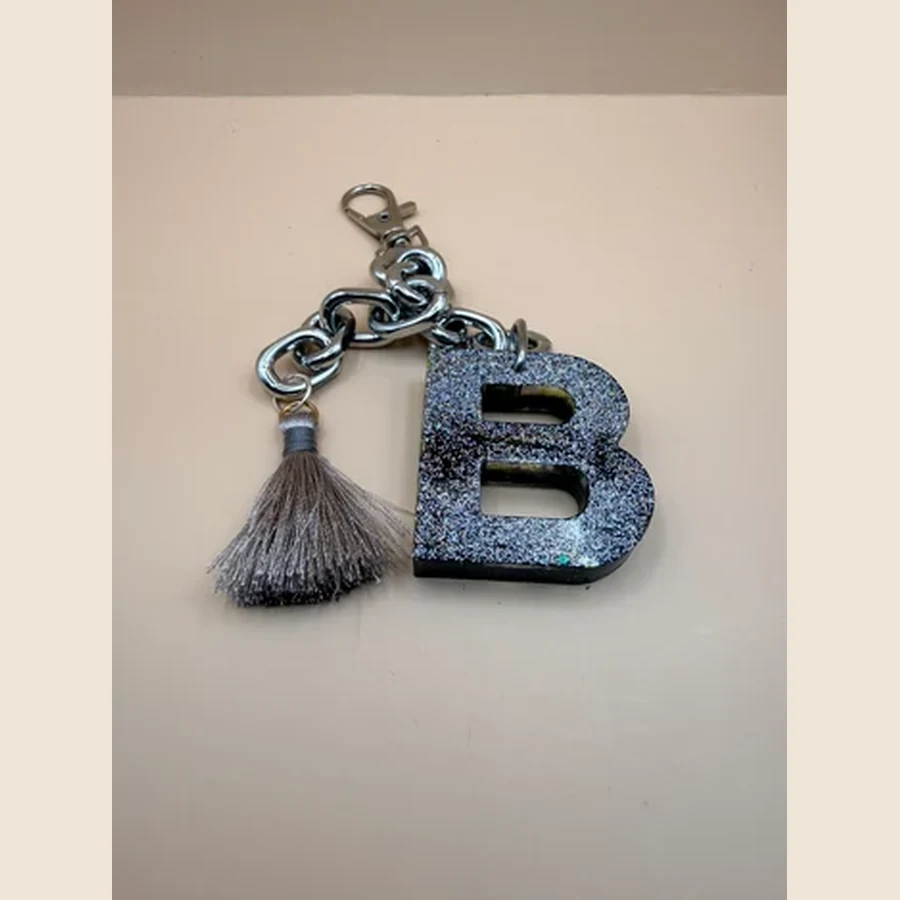 Leuke handgemaakte sleutelhanger met een letter naar keuze en een vrolijk bedeltje. Perfect als persoonlijk cadeautje voor aan je sleutelbos, tas of cadeauverpakking. Gepersonaliseerde sleutelhanger met letter en bedeltje Maak je sleutelbos, tas of cadeau extra persoonlijk met deze handgemaakte sleutelhanger. De sleutelhanger wordt gemaakt met een letter naar keuze en een leuk bijpassend bedeltje.