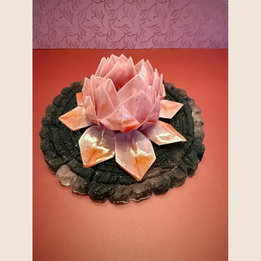 Roze lotusbloem gemaakt van papier met een laagje epoxy. De bloem is op een ronde boomstam bordje geplakt ook van epoxy. Diameter is ongeveer 12cm inclusief lampje