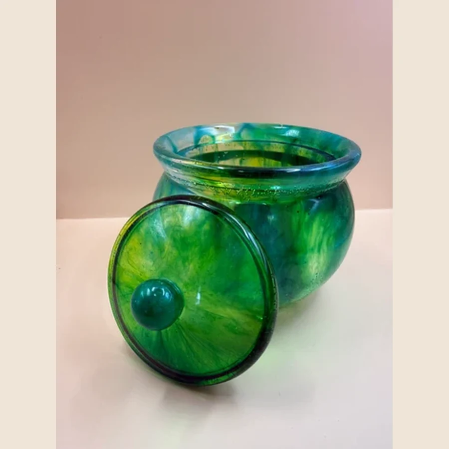 Dit prachtige sierpotje met deksel is een uniek handgemaakt item met een mooie glanzende afwerking. Door de diepe groen- en blauwtinten krijgt het potje een luxe, bijna glasachtige uitstraling. Perfect om kleine spulletjes in te bewaren, zoals sieraden, elastiekjes, paperclips of andere kleine schatten. Ook staat het potje superleuk als decoratie op een kastje, bureau, kaptafel of in de badkamer.
