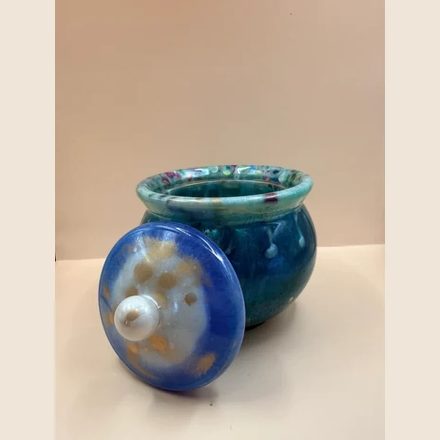 Mooi handgemaakt groen sierpotje met deksel. Leuk als decoratie, bewaarpotje voor kleine spulletjes of als uniek cadeautje. Met liefde gemaakt door By Jaike. Productomschrijving Dit prachtige groen/blauw sierpotje met deksel is een uniek handgemaakt item met een mooie glanzende afwerking. Door de diepe groen- en blauwtinten krijgt het potje een luxe, bijna glasachtige uitstraling.